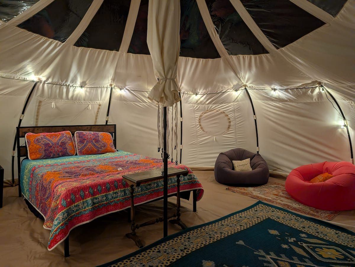 Queen bed and seating inside the Vineyard tent